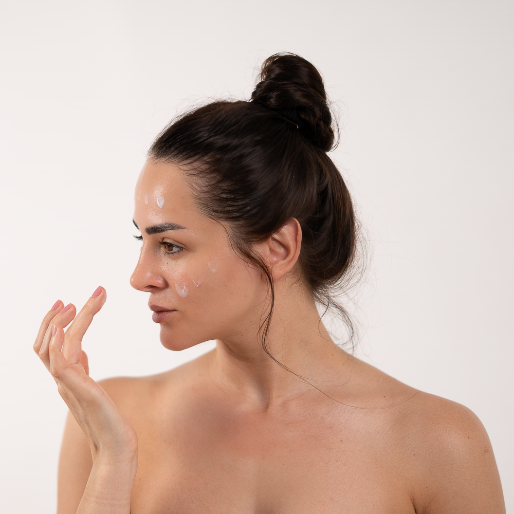 girl putting cream dots on her face